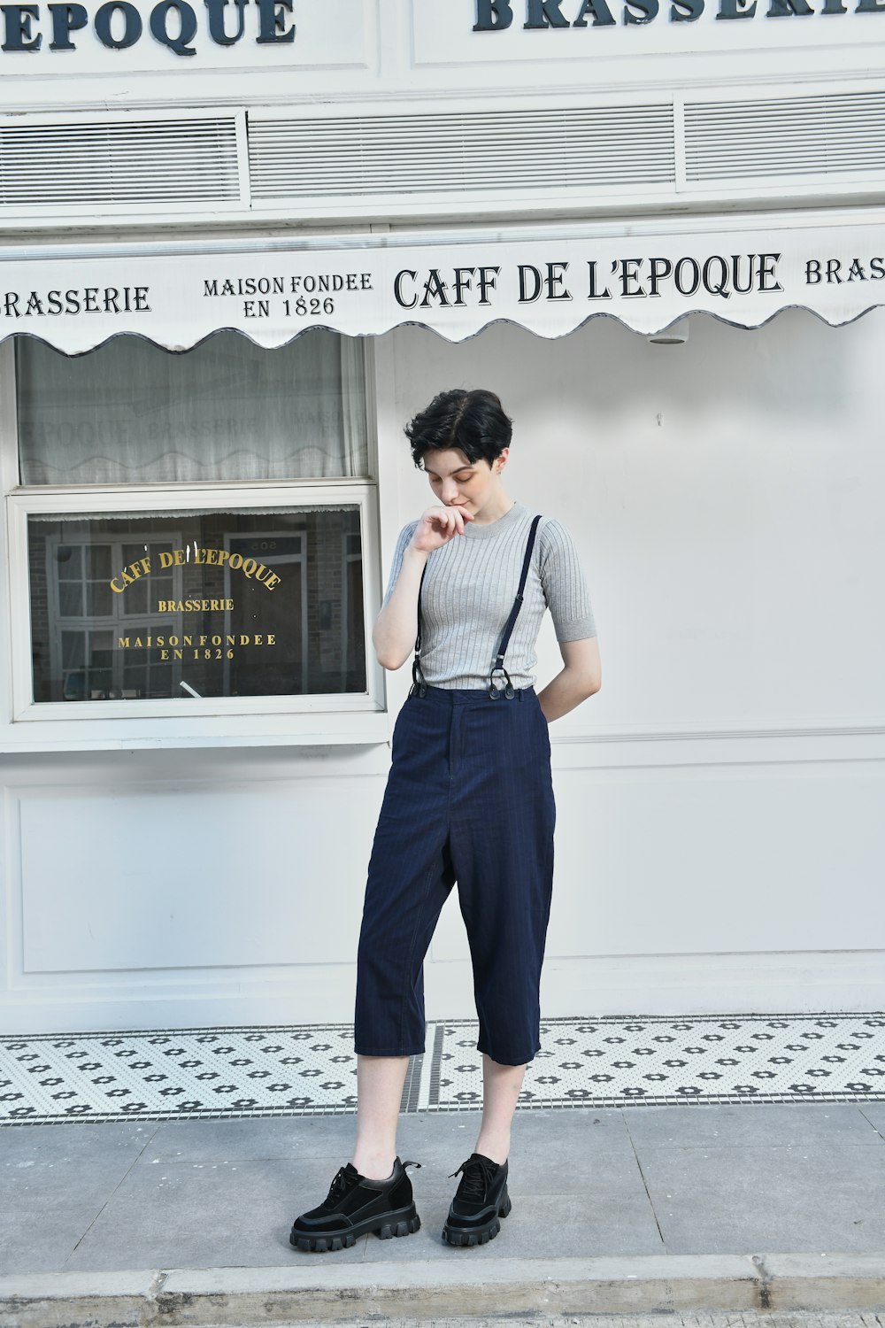 a woman standing on a sidewalk in front of a store