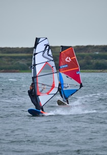 a person windsurfing in the ocean on a cloudy day