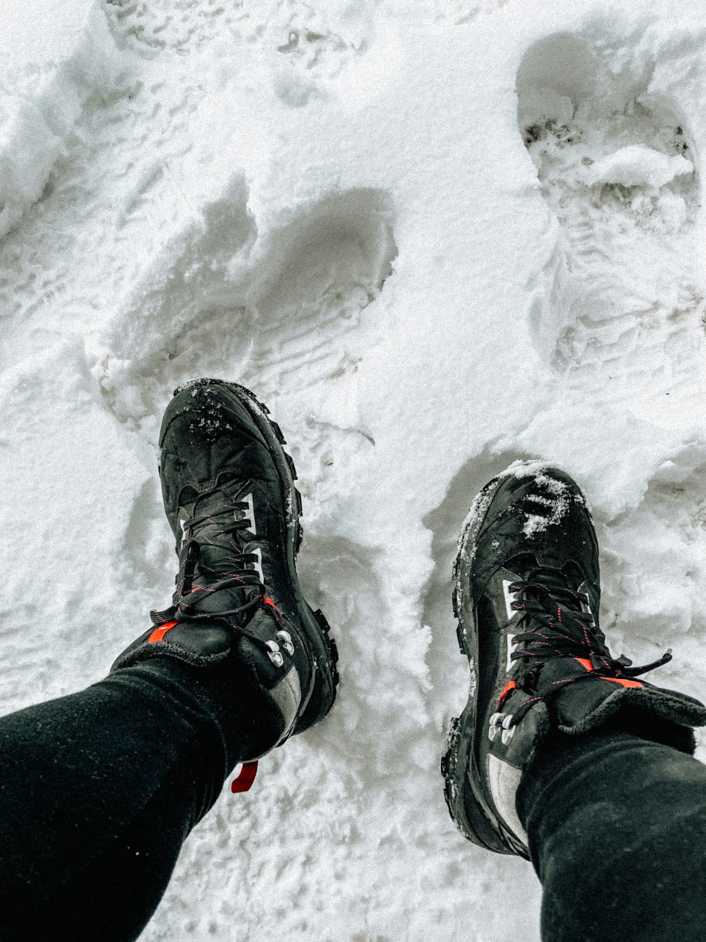 a person standing in the snow with their feet in the snow