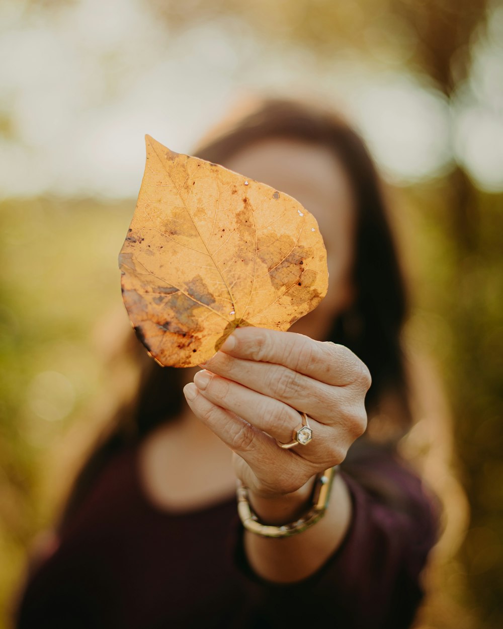 a woman holding a leaf in her hand