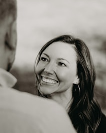 A confident woman smiling while engaging in a meaningful conversation.
