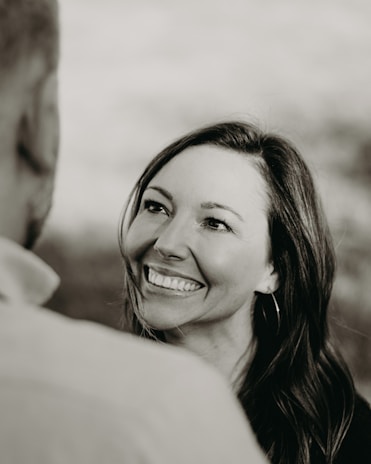 A vibrant image of a woman smiling while engaging in a conversation.