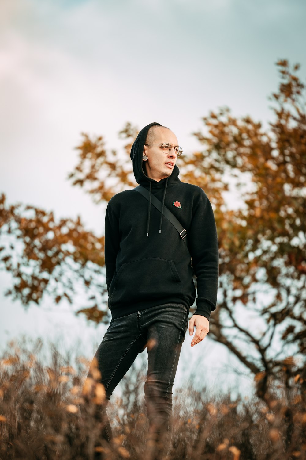 a man in a black hoodie standing in a field