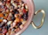 Close-up of a copper serving bowl gleaming under soft lighting, filled with colorful fruits.