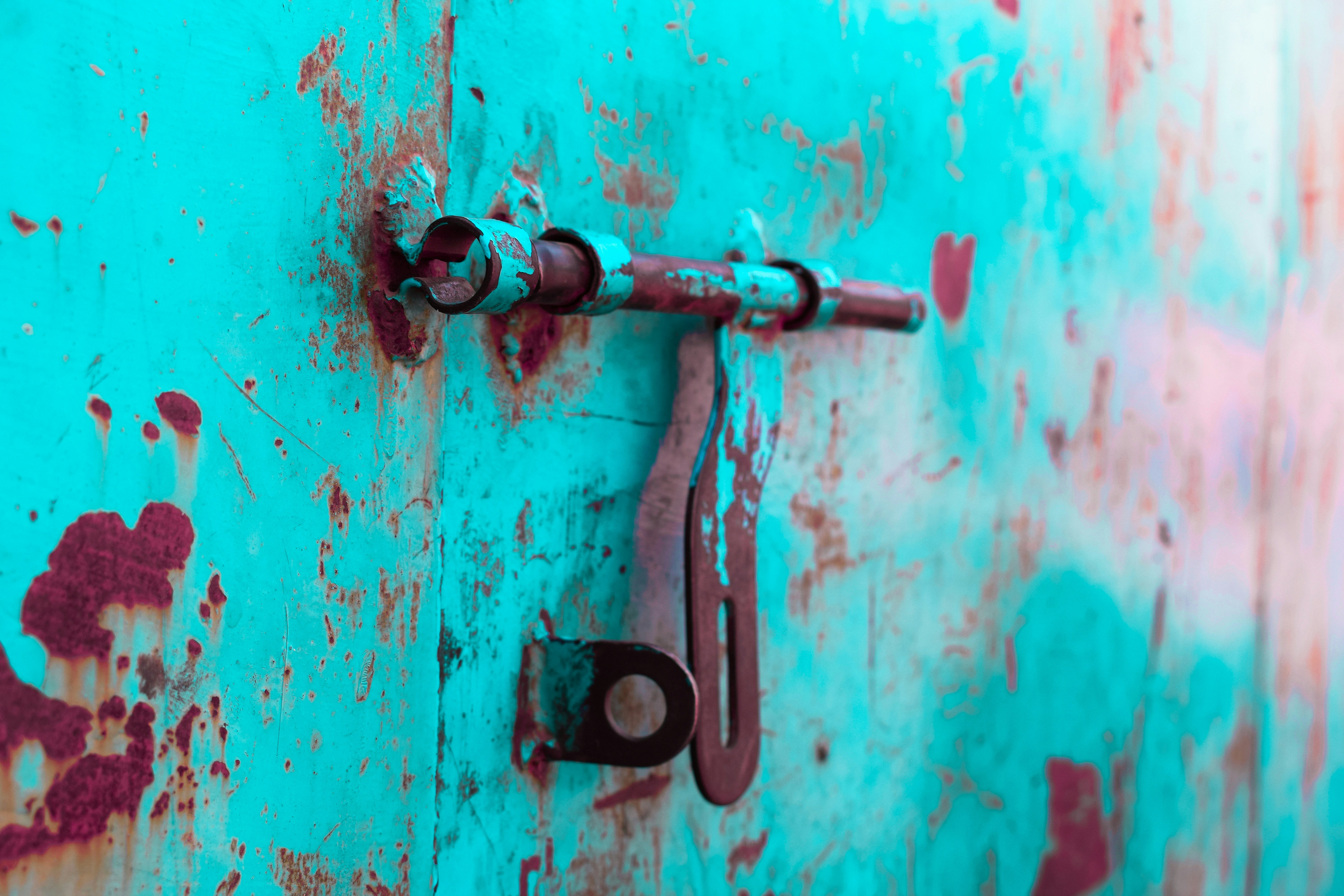 a rusted metal handle on a blue wall