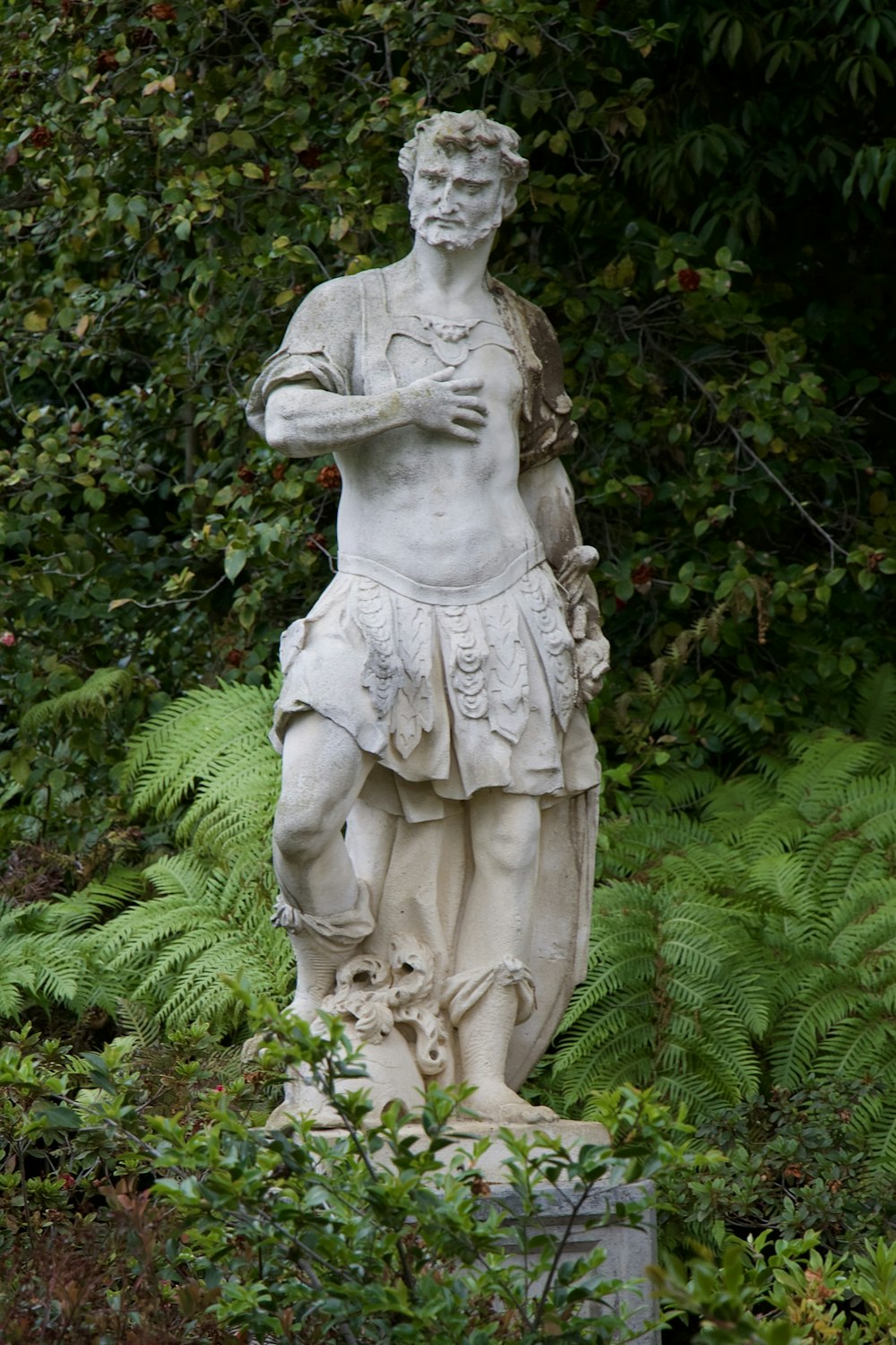 a statue of a man standing in a garden