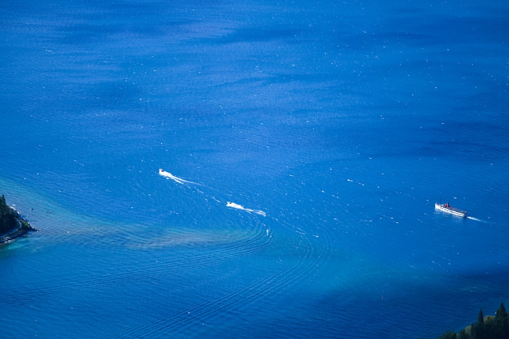 a couple of boats floating on top of a large body of water