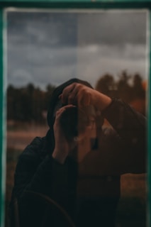 a person holding a cell phone up to their face