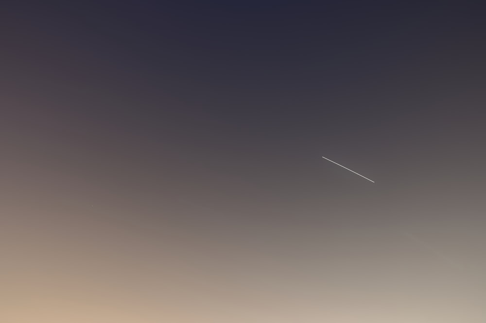 a plane is flying in the sky over a field