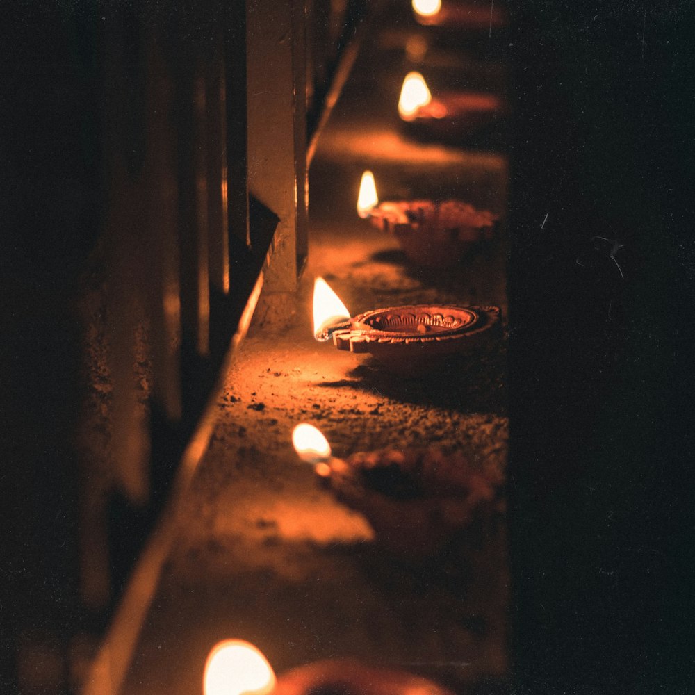 a row of lit candles sitting next to each other