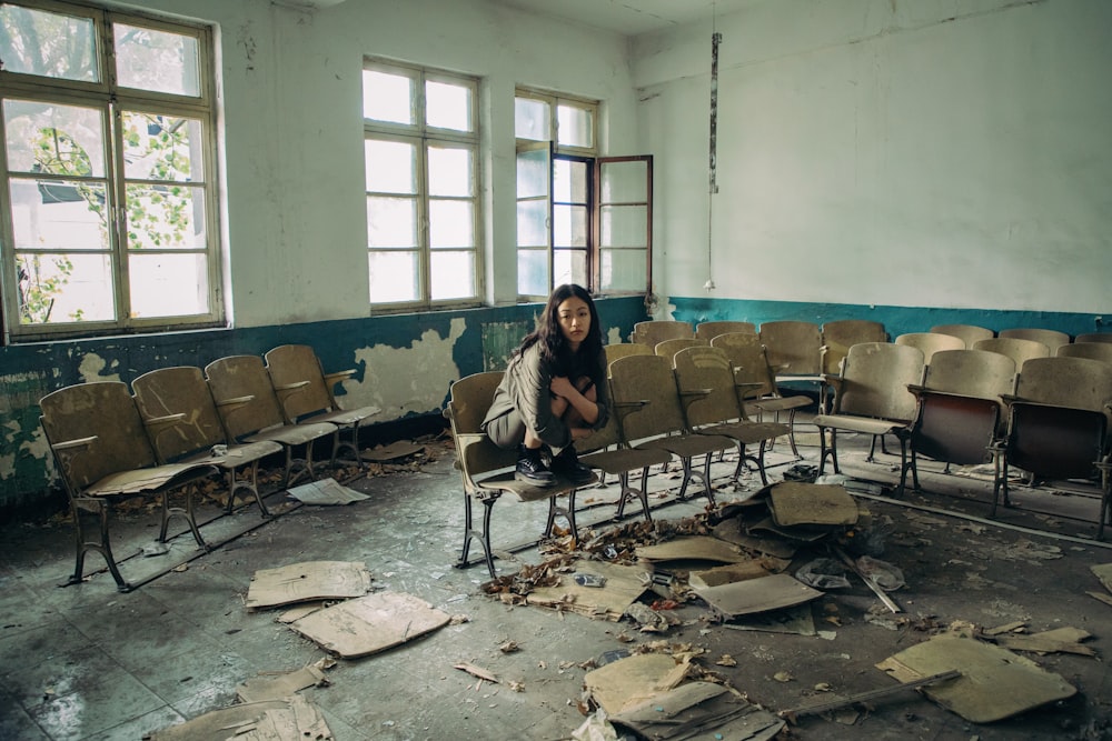 a woman sitting on a chair in an empty room