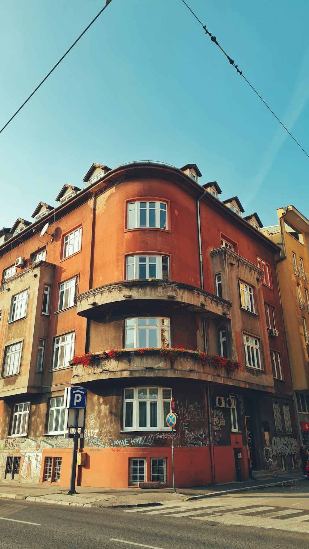 Un edificio rojo con muchas ventanas al lado de una calle