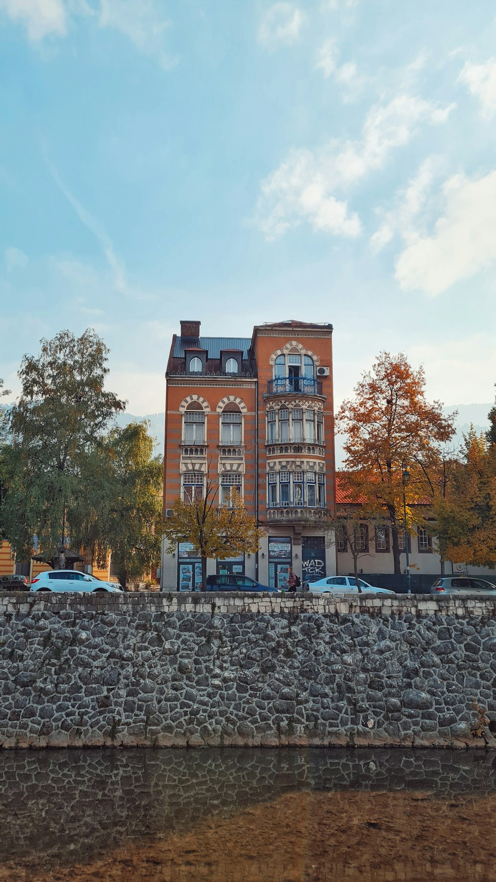 a large brick building next to a stone wall