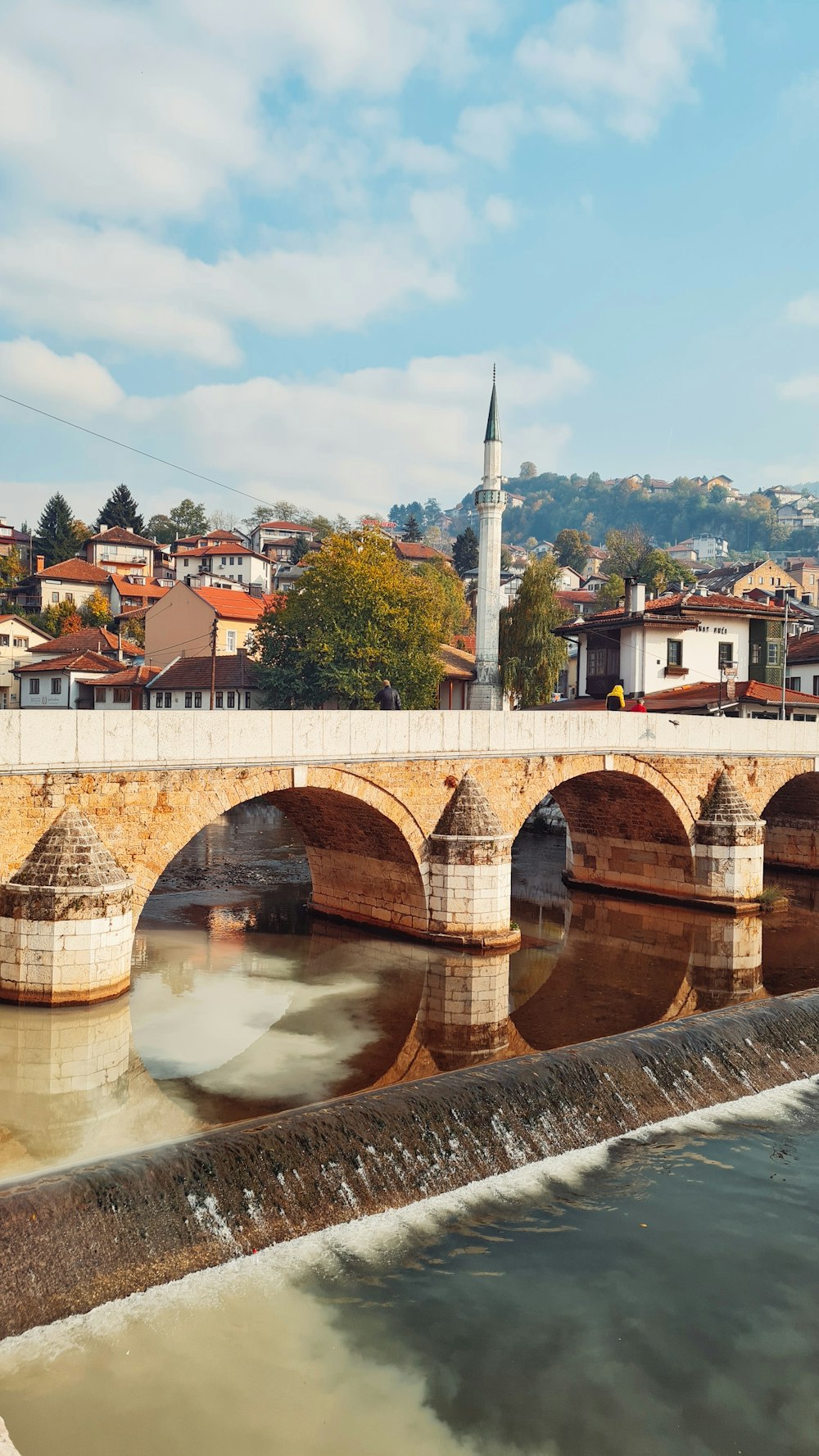 a bridge over a body of water with buildings in the background