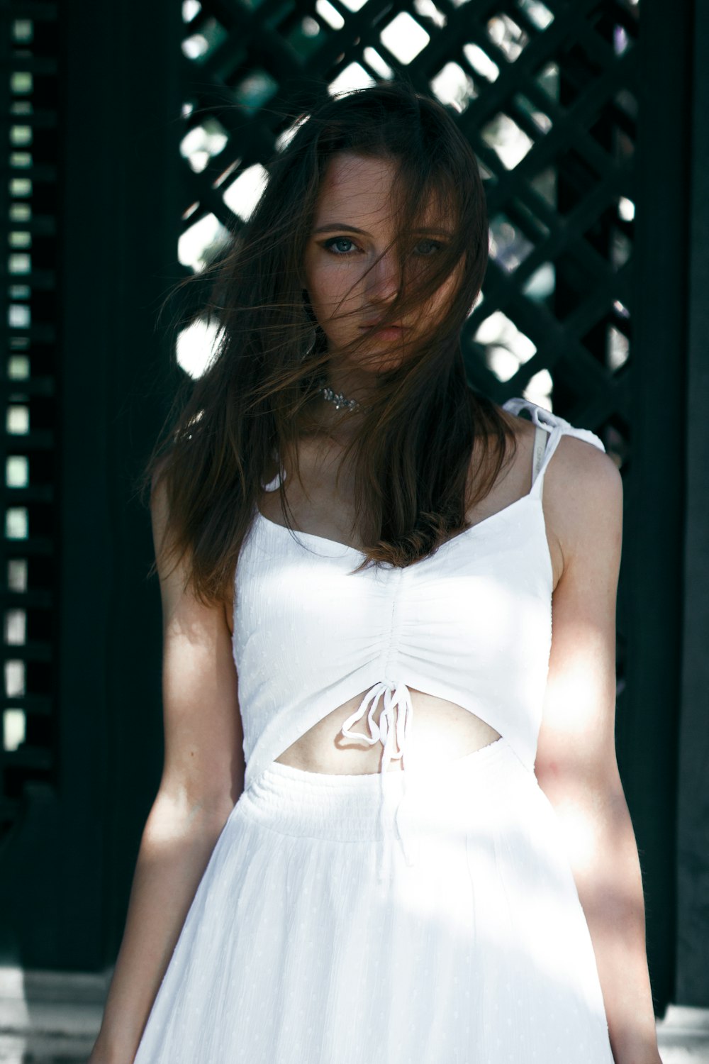 uma mulher em um vestido branco está posando para uma foto