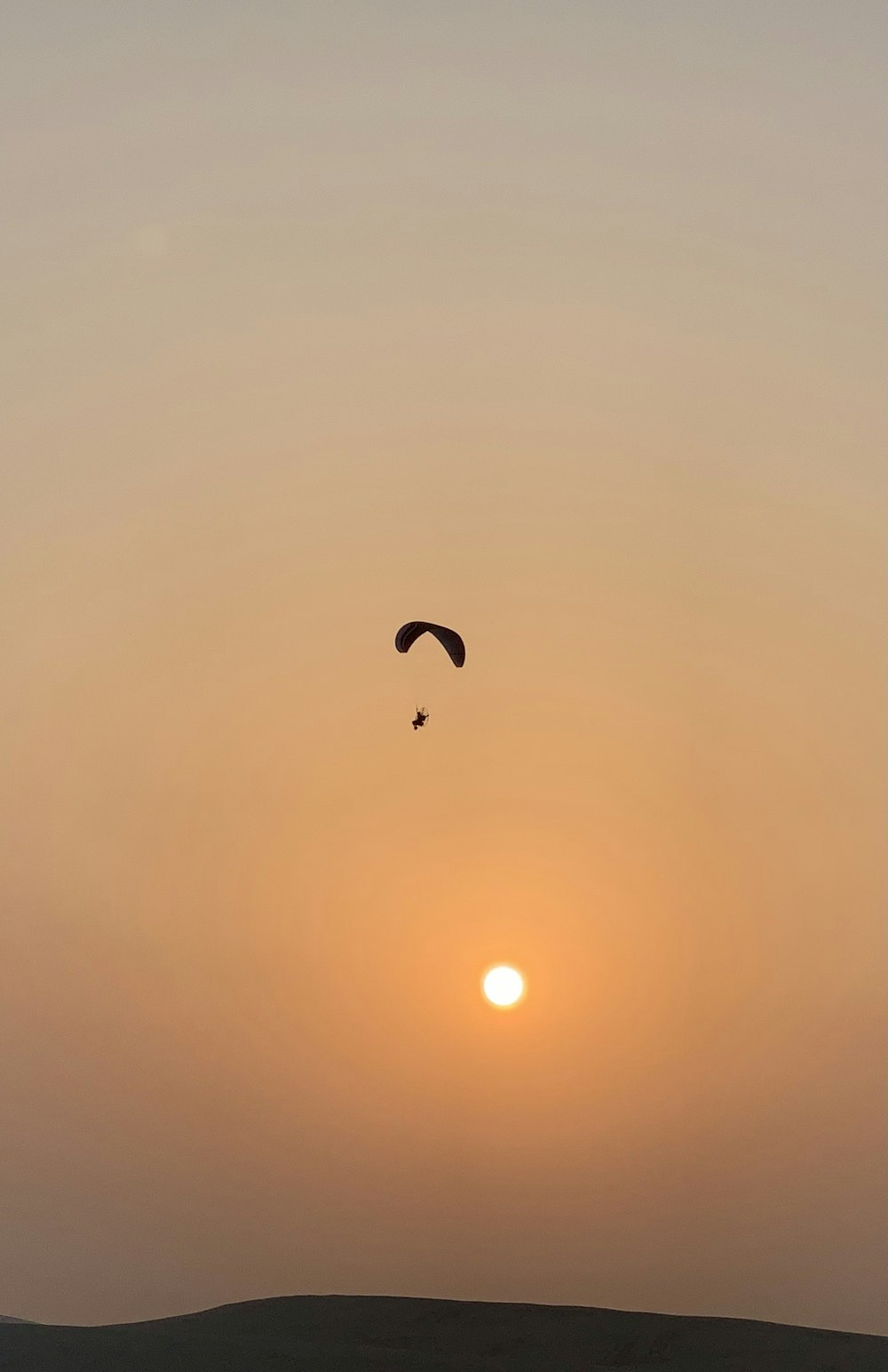 a kite flying in the sky at sunset