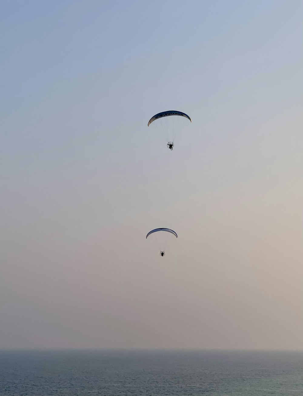 Un couple de parachutes ascensionnels survole l’océan