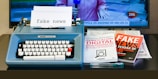 a blue typewriter sitting on top of a desk next to a tv
