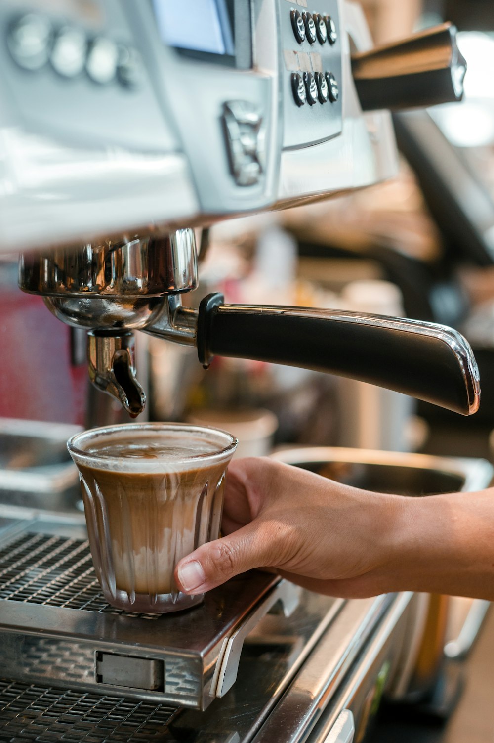 a person is filling a cup of coffee