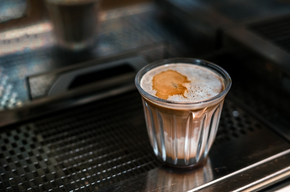 a glass of liquid sitting on top of a stove