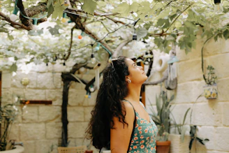 A serene outdoor scene of a womb workshop in progress, with women gently holding herbs and sunlight filtering through leaves.