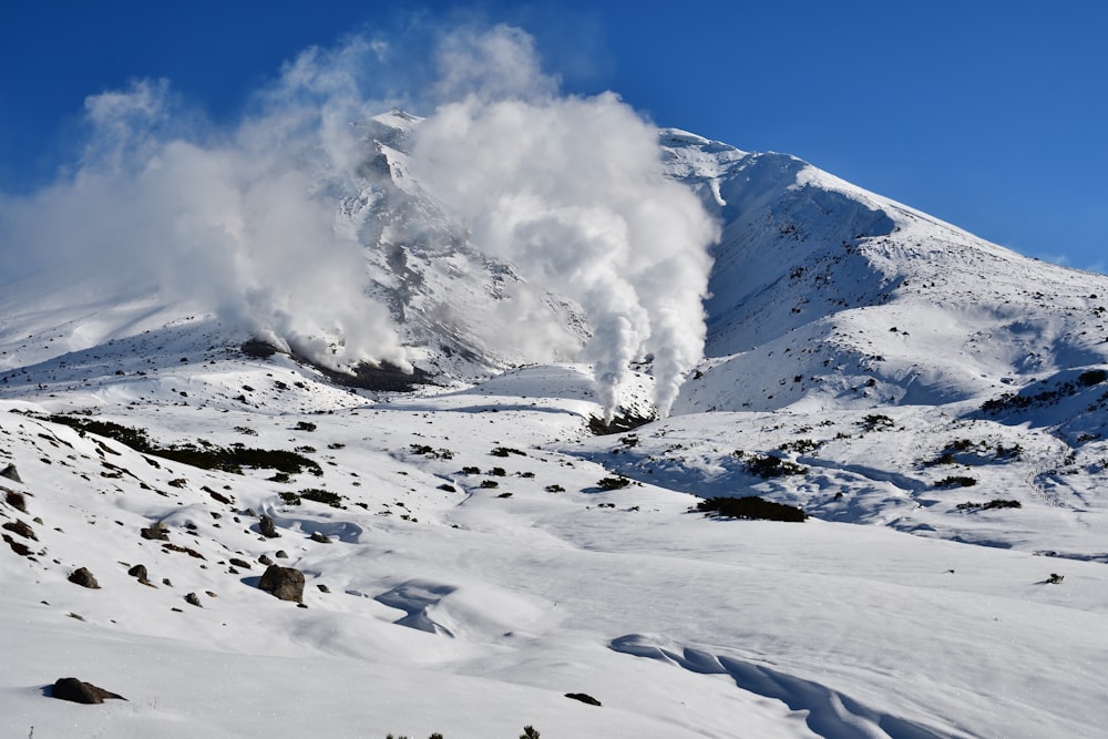 a mountain covered in snow with steam coming out of it