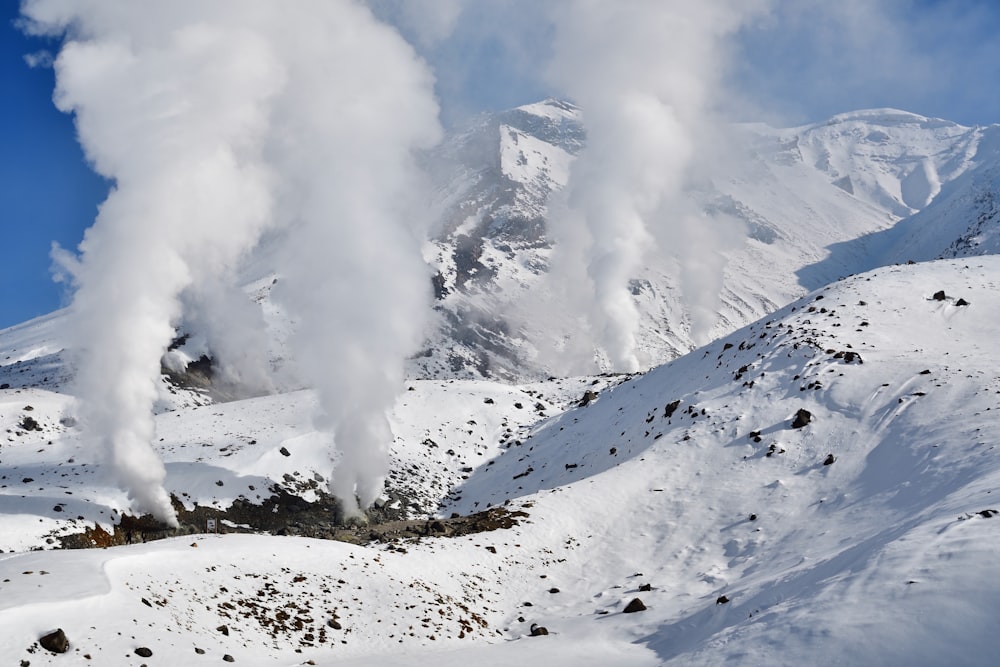 a mountain covered in snow with steam coming out of it