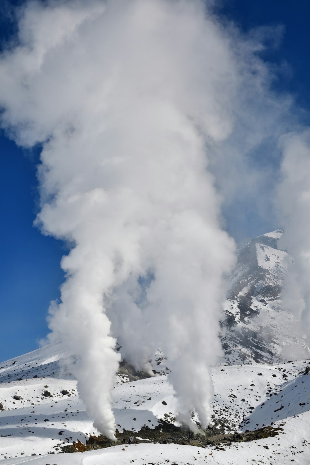 a snow covered mountain with steam coming out of it