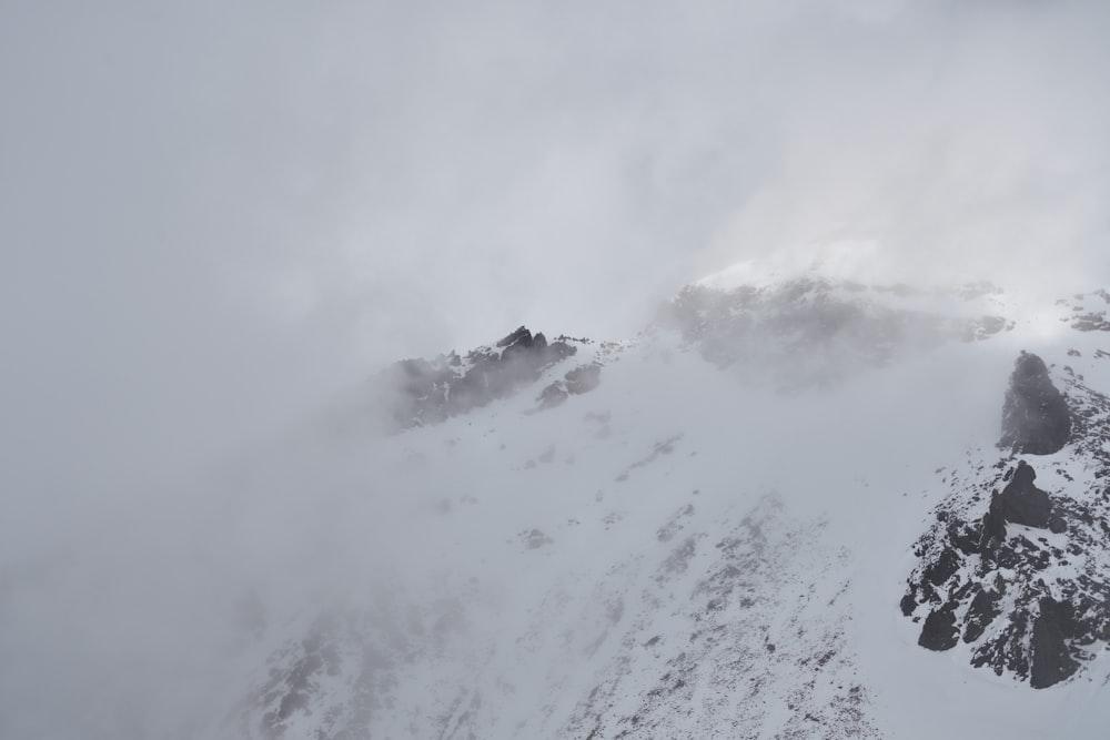 a very tall mountain covered in snow and clouds