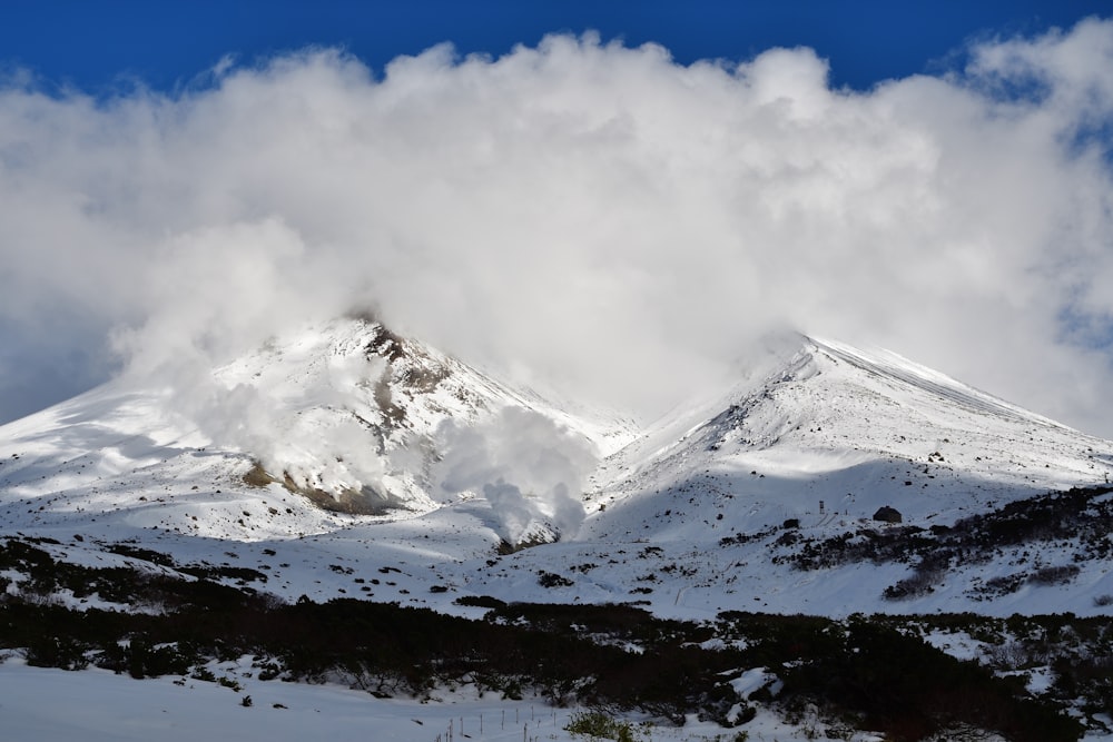 a mountain covered in snow under a cloudy sky