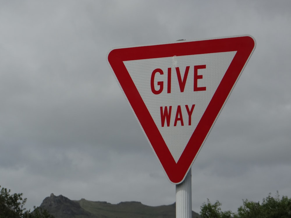 a red and white sign that says give way