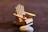 Close-up of a delicate miniature doll sitting on a handcrafted wooden chair.