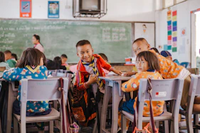 a group of children sitting at desks in a classroom