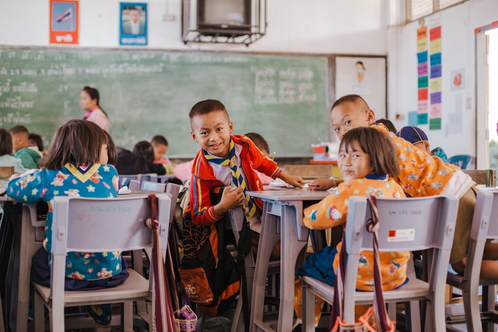 a group of children sitting at desks in a classroom