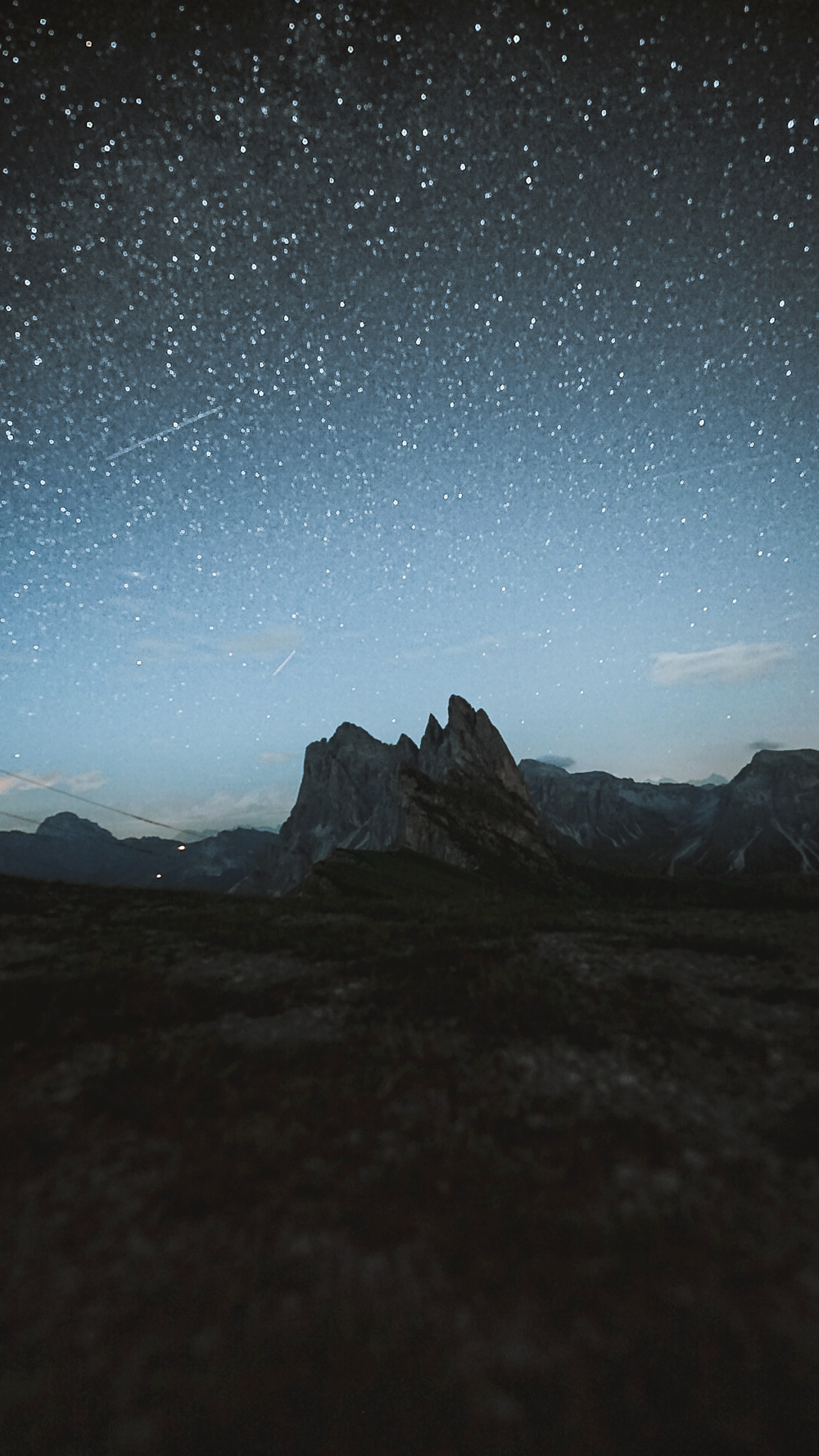 a night sky with stars above a mountain range