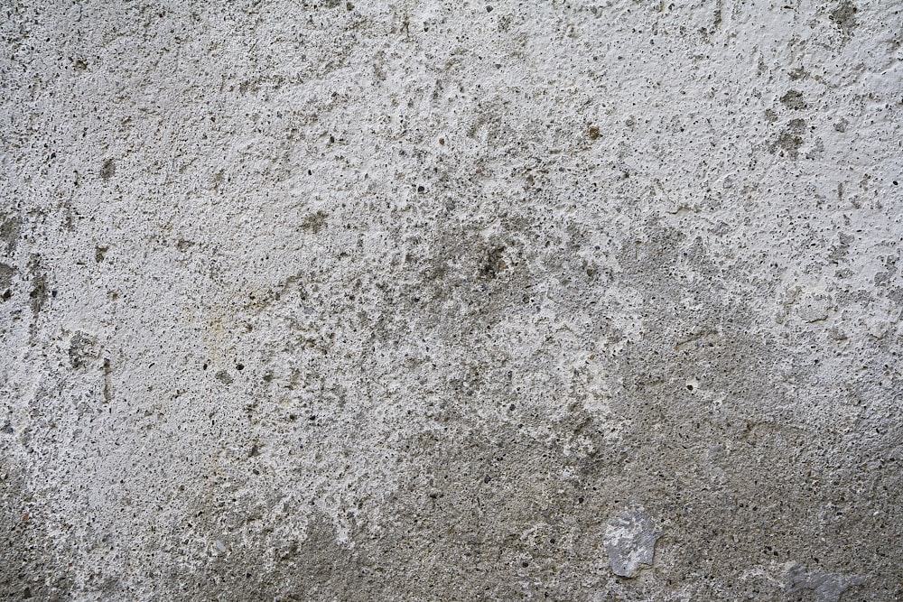 작은 흙 조각이있는 콘크리트 벽