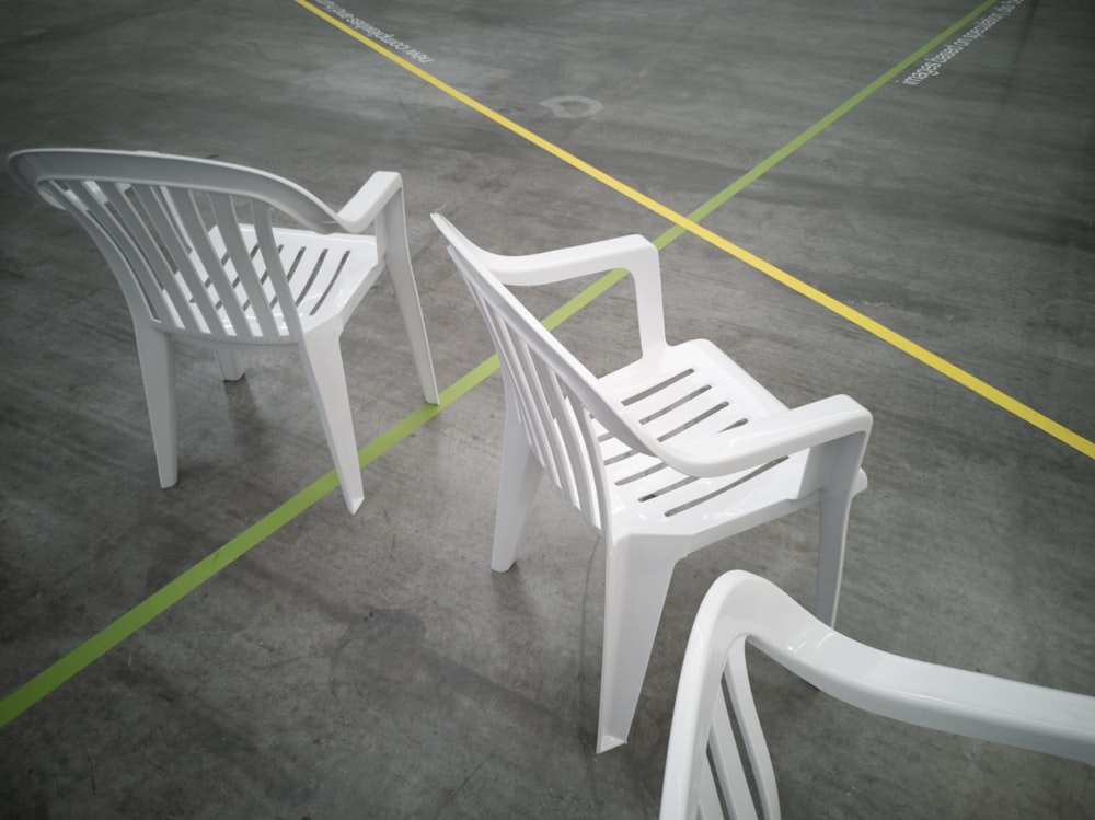 Un par de sillas blancas sentadas una al lado de la otra
