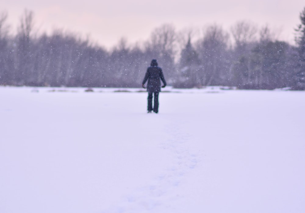 a person walking through a snow covered field