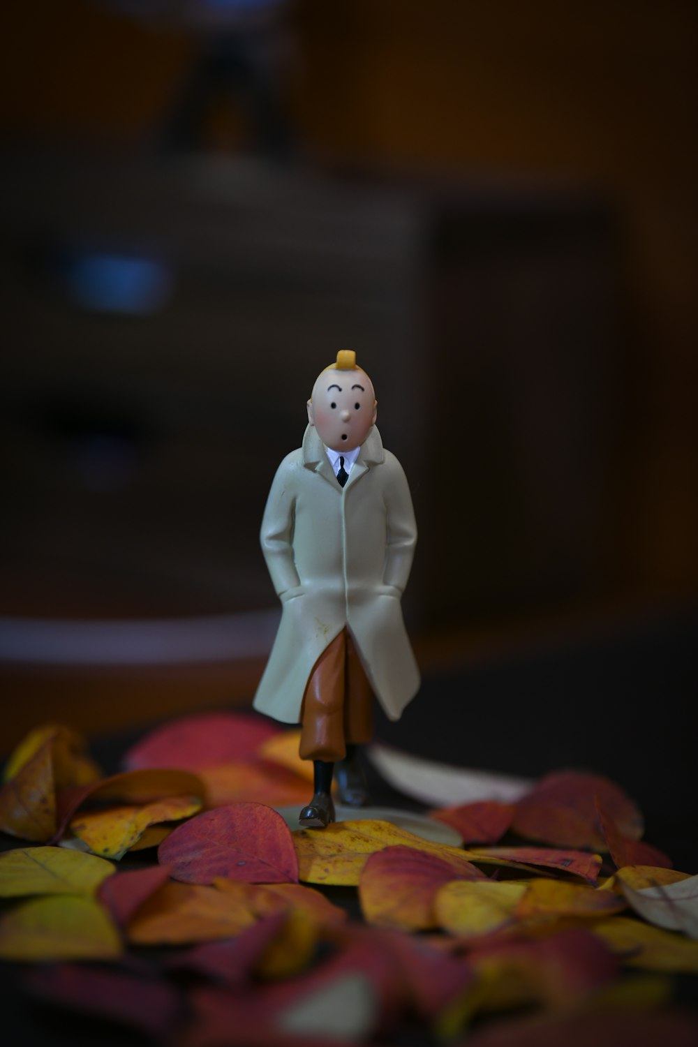 a figurine of a man standing on a pile of leaves