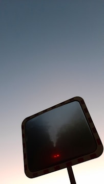 Close-up of a red and white retro-reflective highway sign mounted on a sturdy MS structure along an expressway