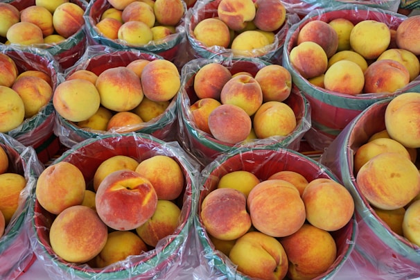 a bunch of baskets filled with lots of peaches