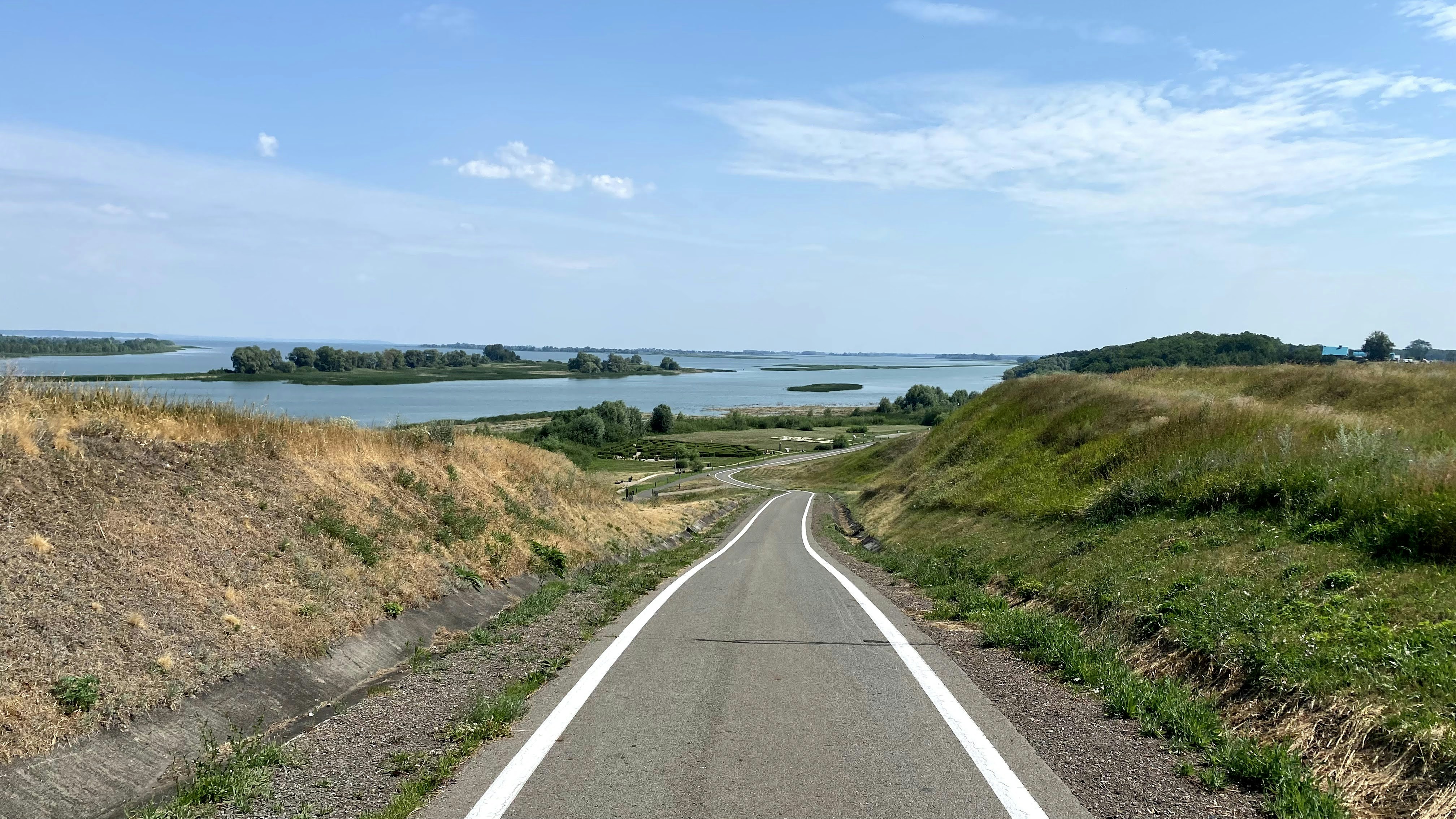 Un camino vacío con vistas a un lago en la distancia