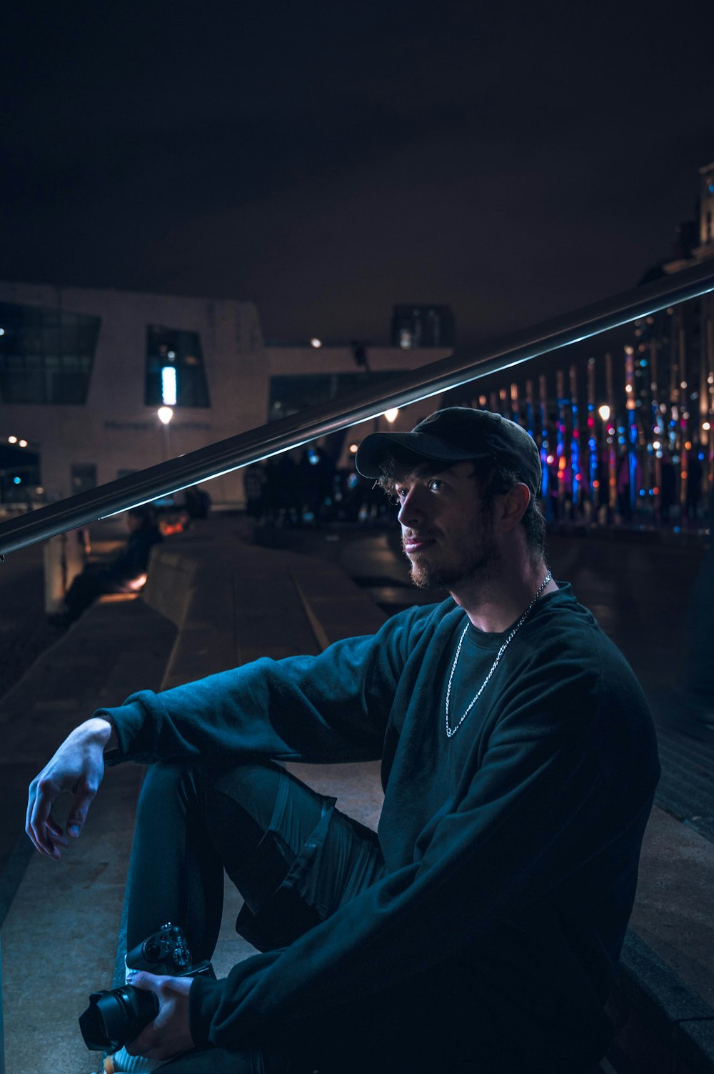 a man sitting on a ledge at night