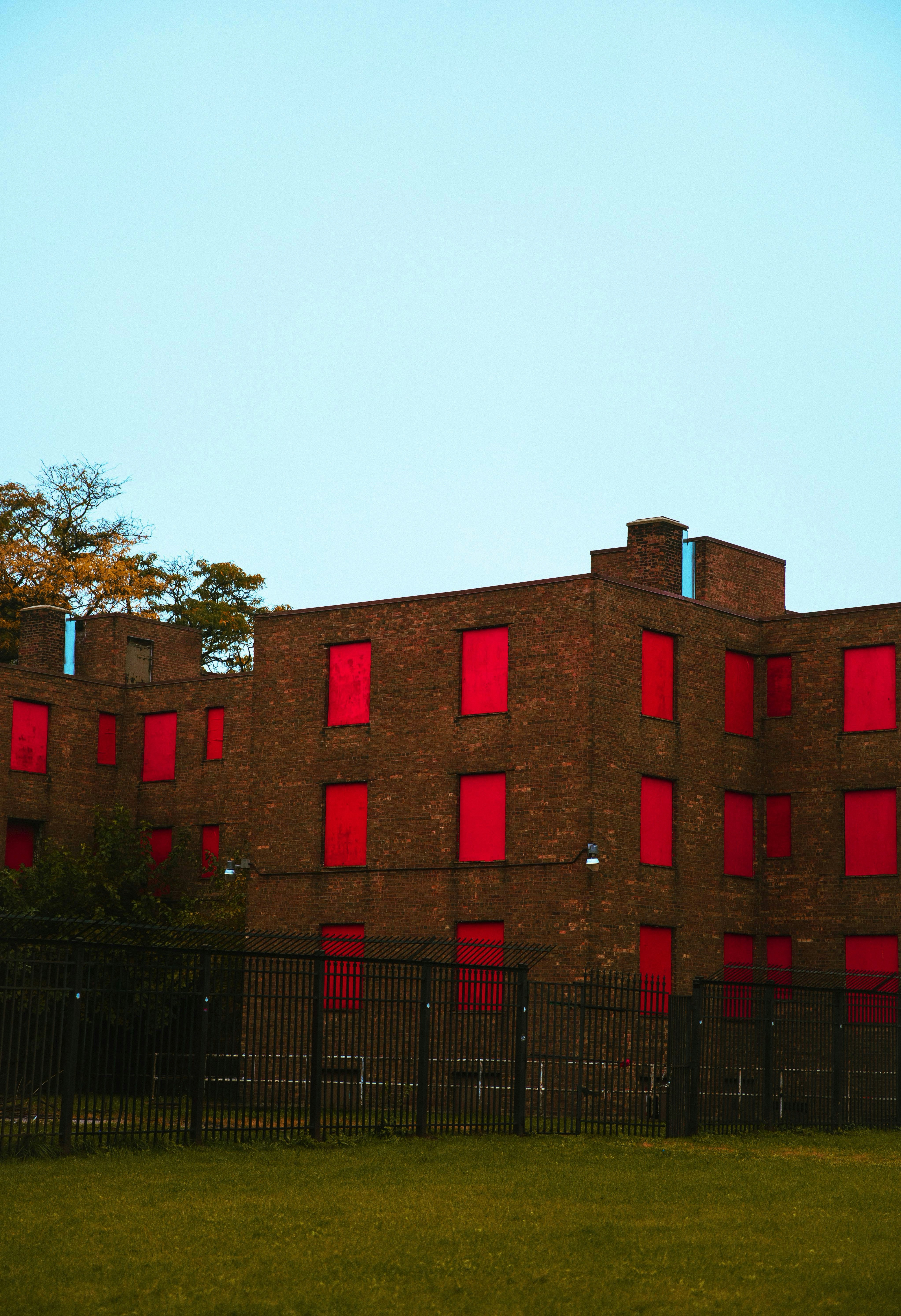 A building with red windows and a black fence photo – Free Urban Image ...