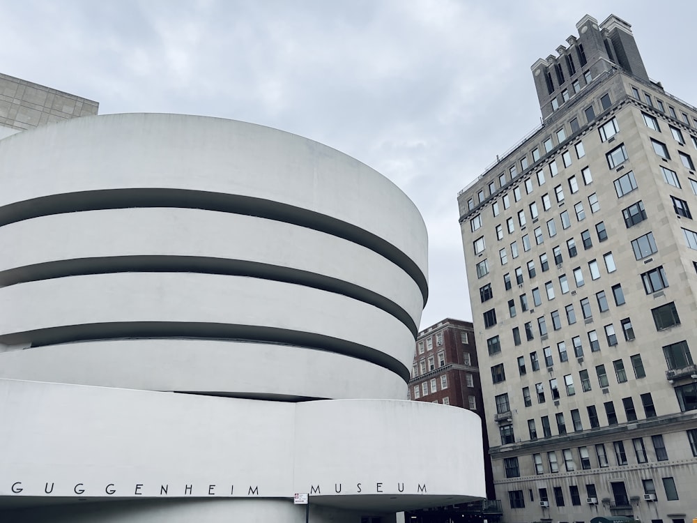 un grand bâtiment avec une structure circulaire blanche devant lui