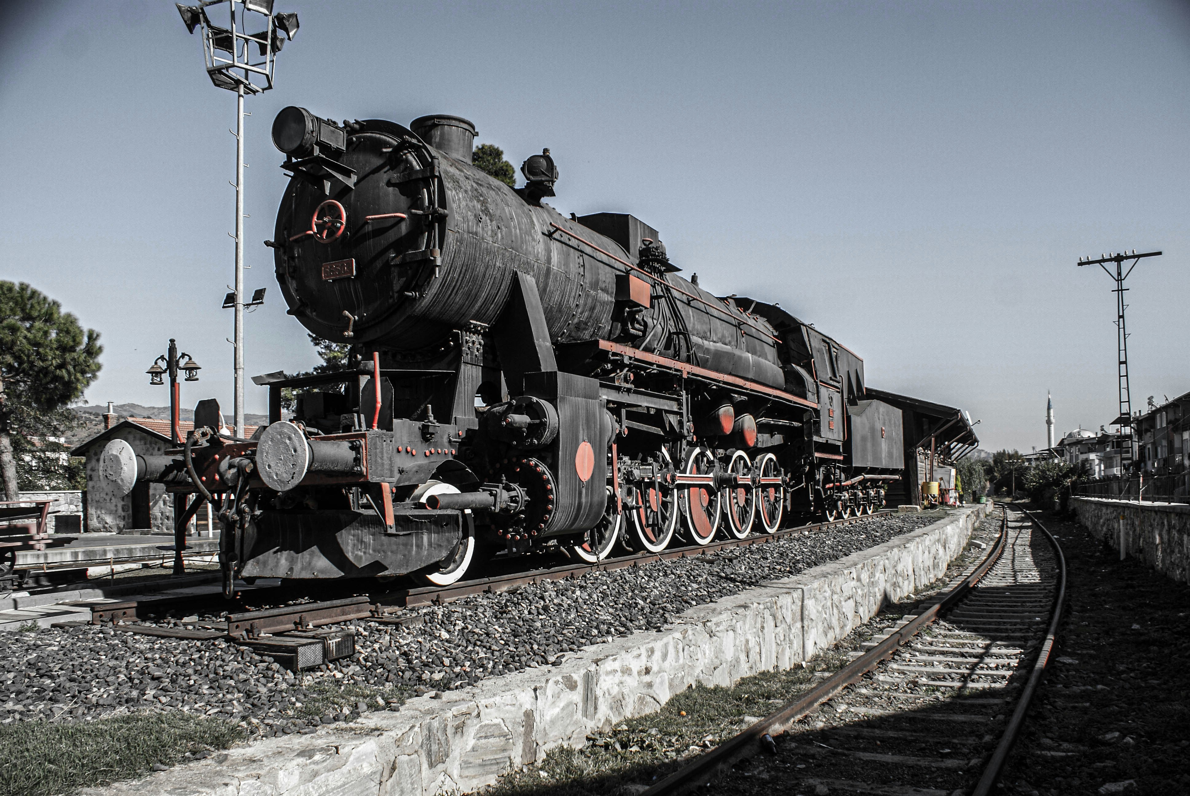 Classic 4-4-2 steam locomotive on open track, golden hour light, dramatic sky, dark steel body