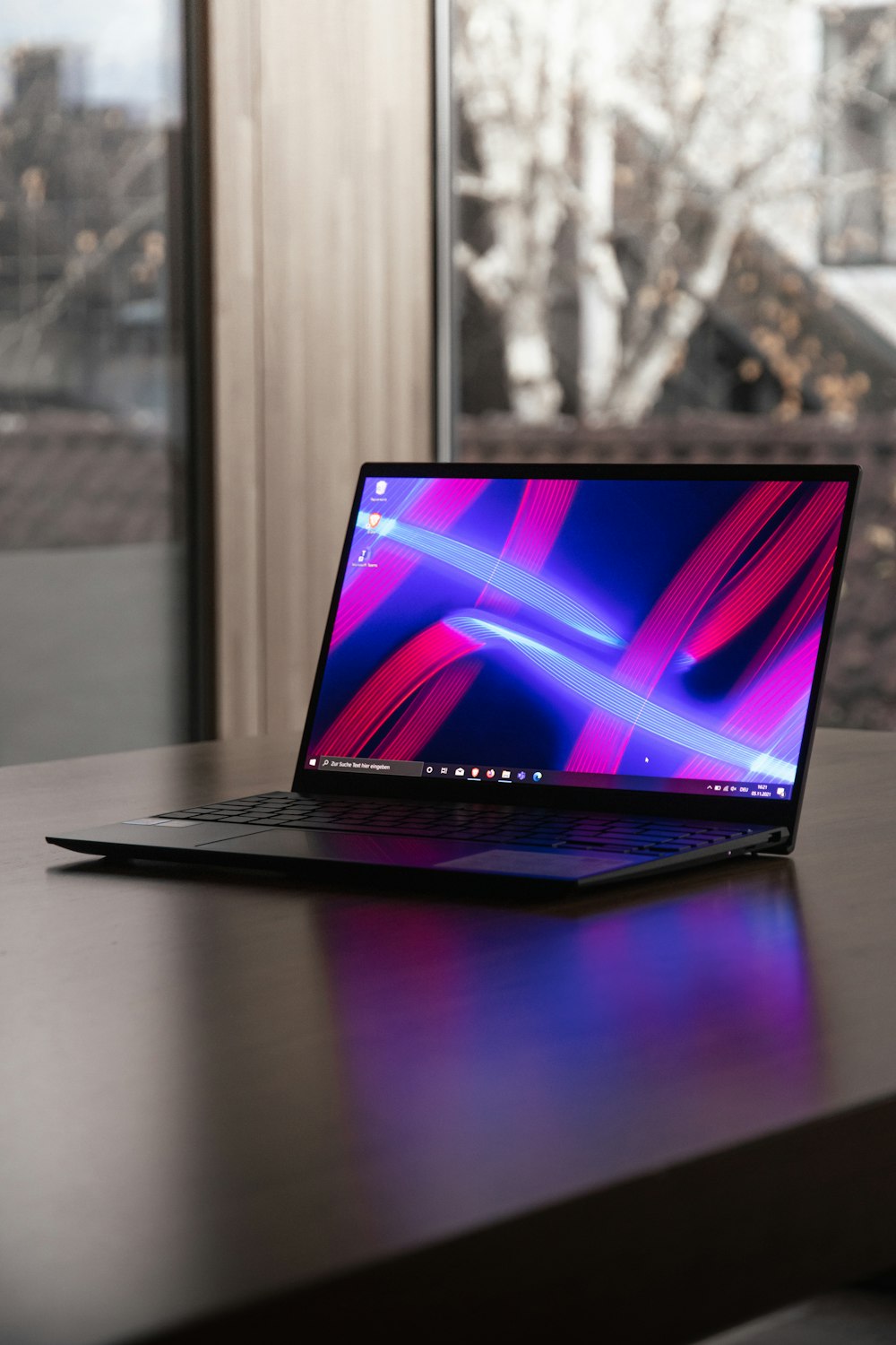 a laptop computer sitting on top of a wooden desk