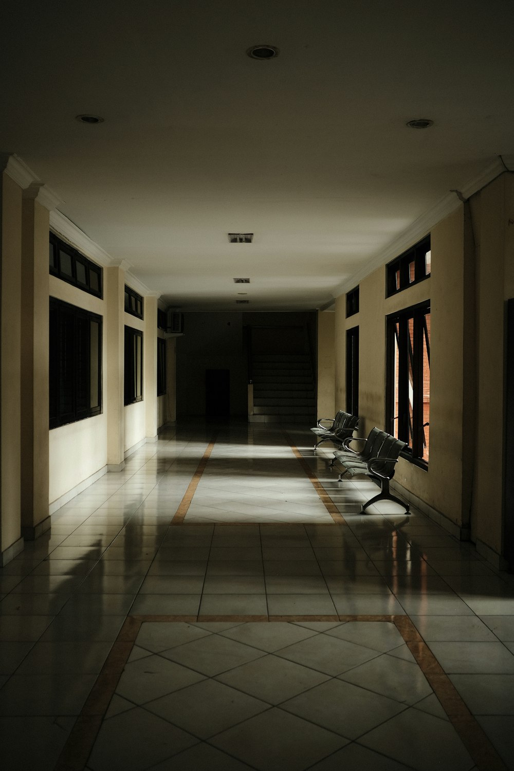 a long hallway with benches and windows in it