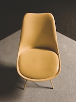 a yellow chair sitting on top of a carpeted floor