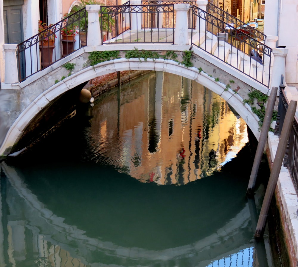 a bridge over a canal with a building in the background